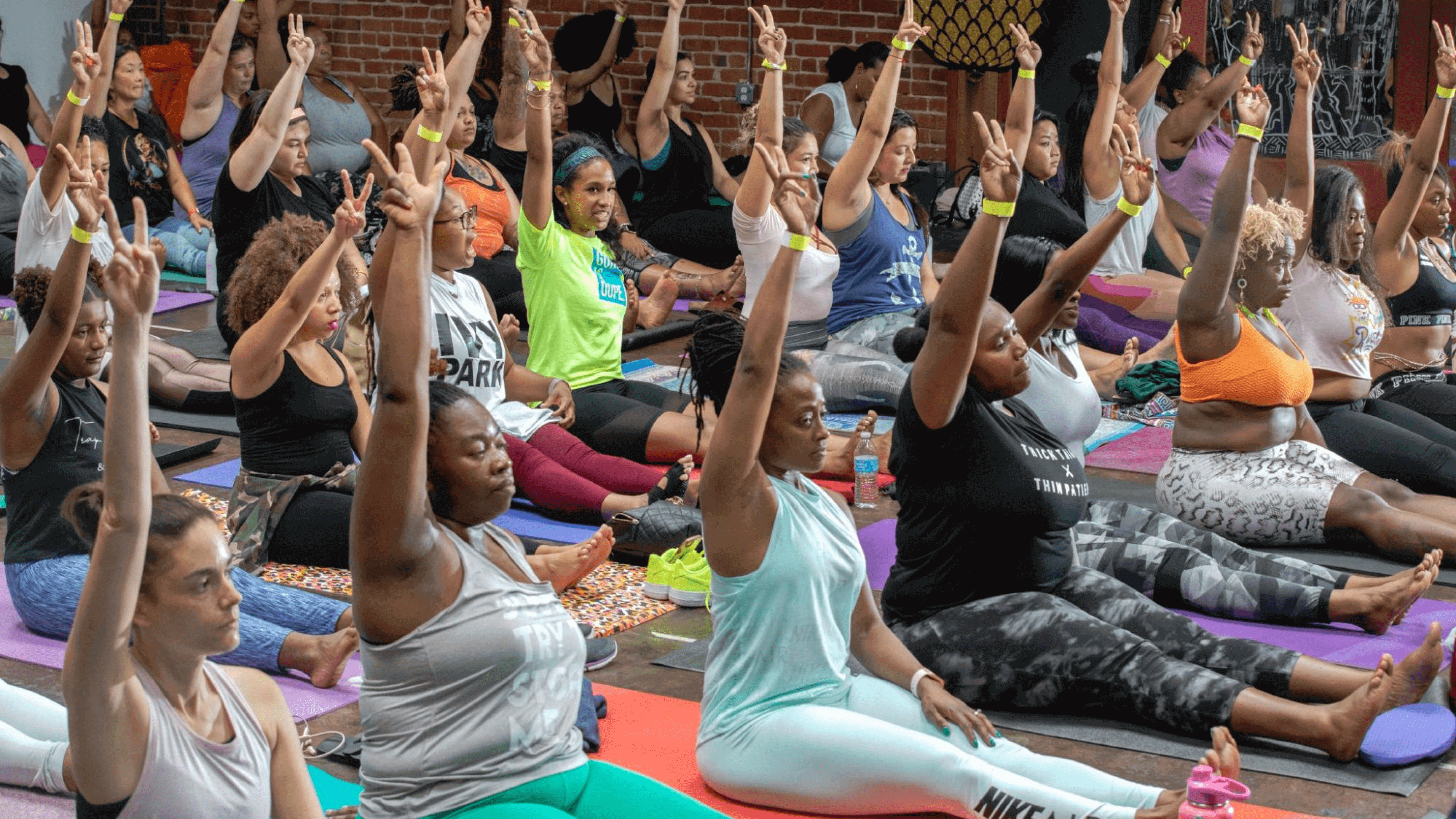 People raising their hands at a yoga event