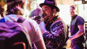 Man on stage with hat and microphone