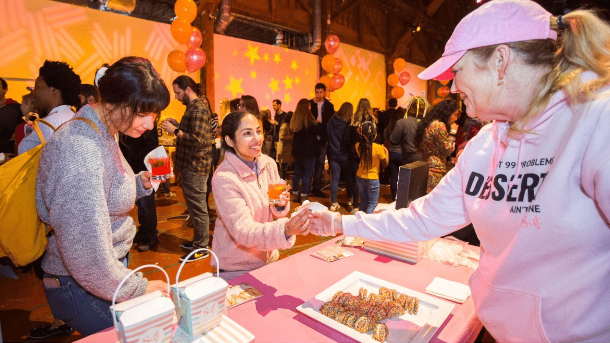 A vendor handing a cookie to a guest