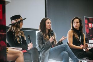 three woman speaking on stage