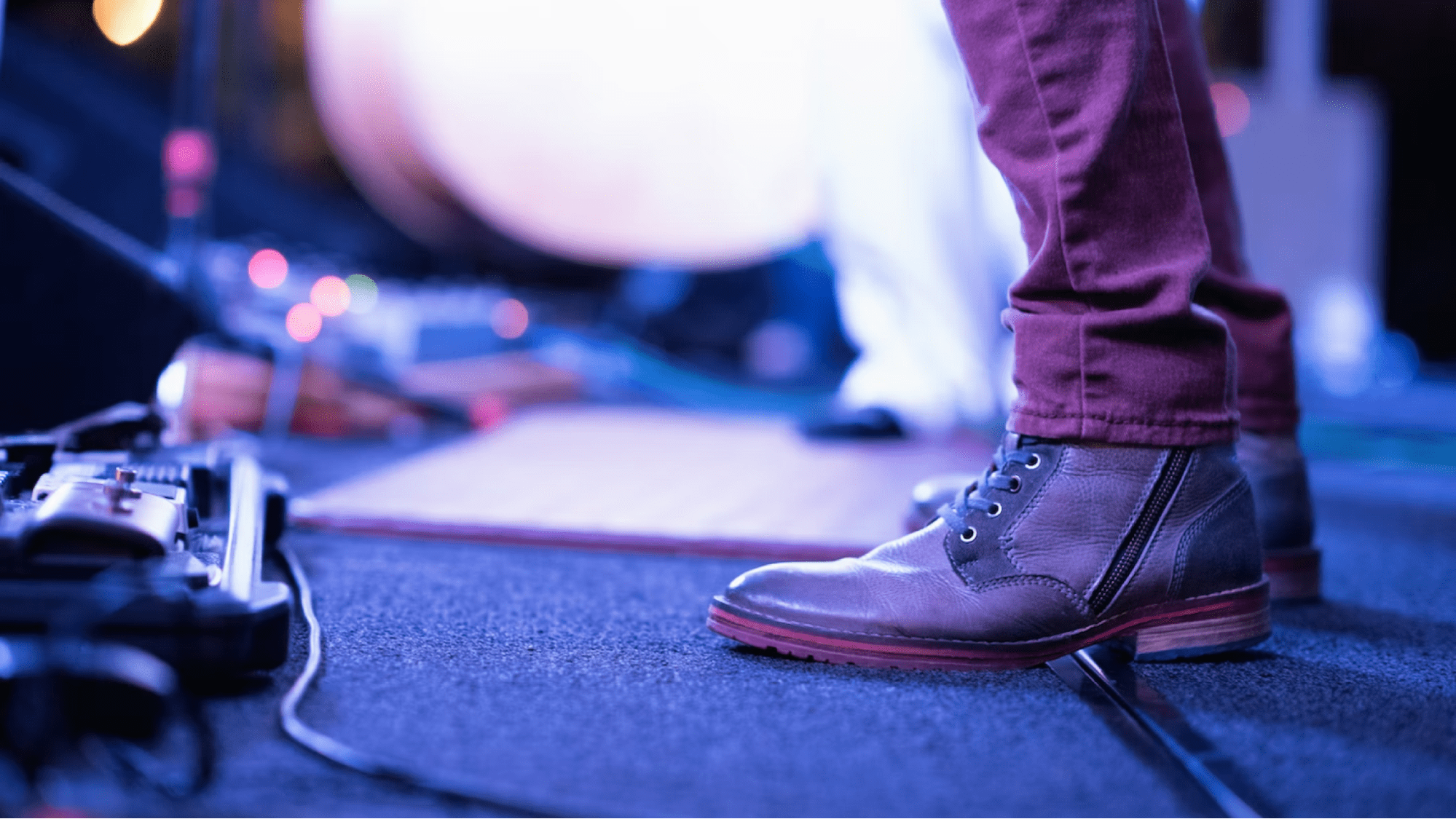 Member of a band's legs and boots on stage