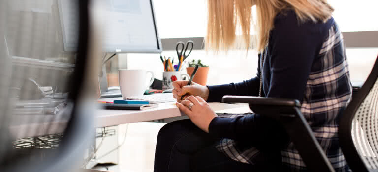 An image of a woman at a desk contacting event sponsors.