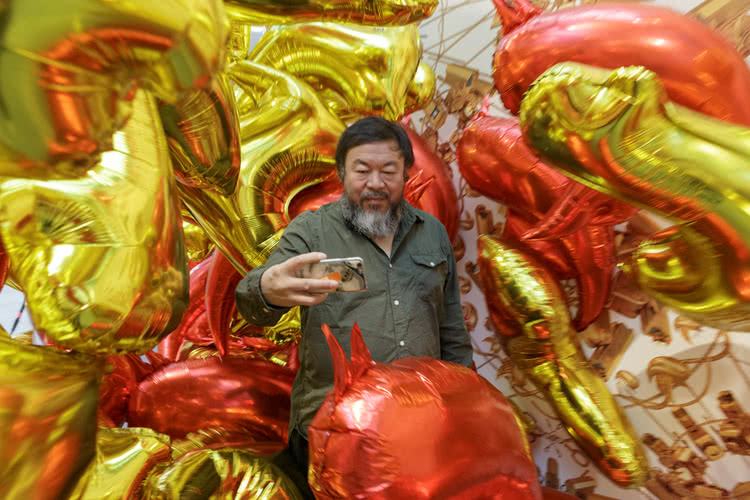 Ai WeiWei takes a selfie with his installation ‘Caonima and Bird Balloons’ 