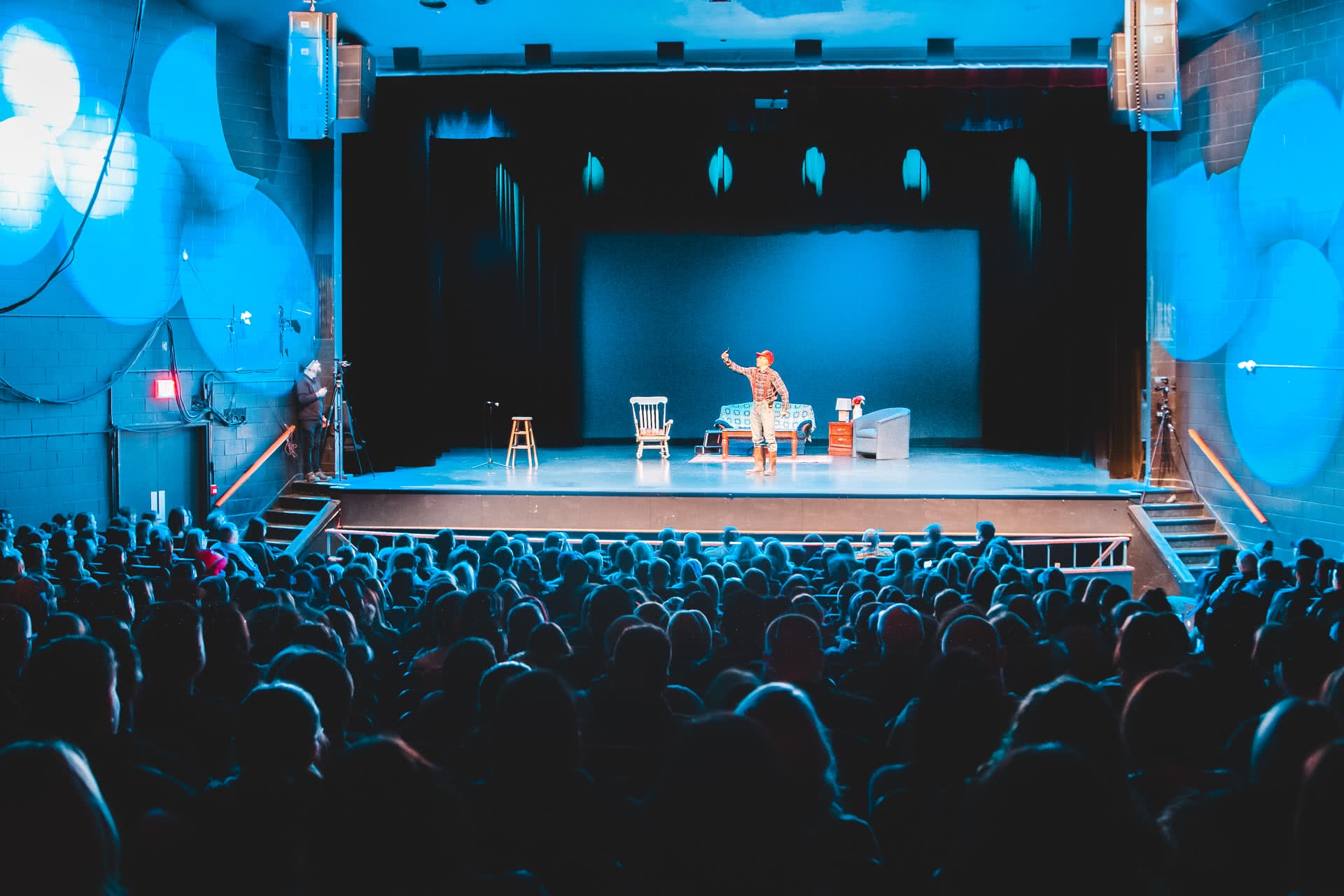 An image of a performer on a stage in front of a large crowd.