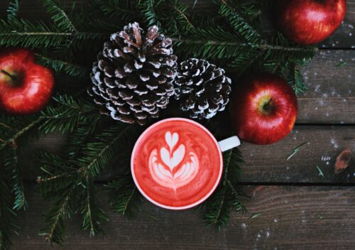 A festive latte next to a Christmas wreath