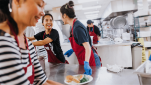 People laughing while serving food