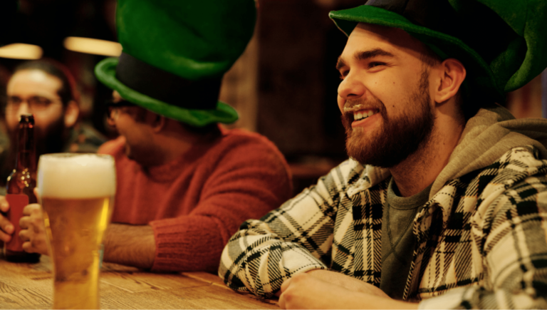A person drinking beer in a green top hat