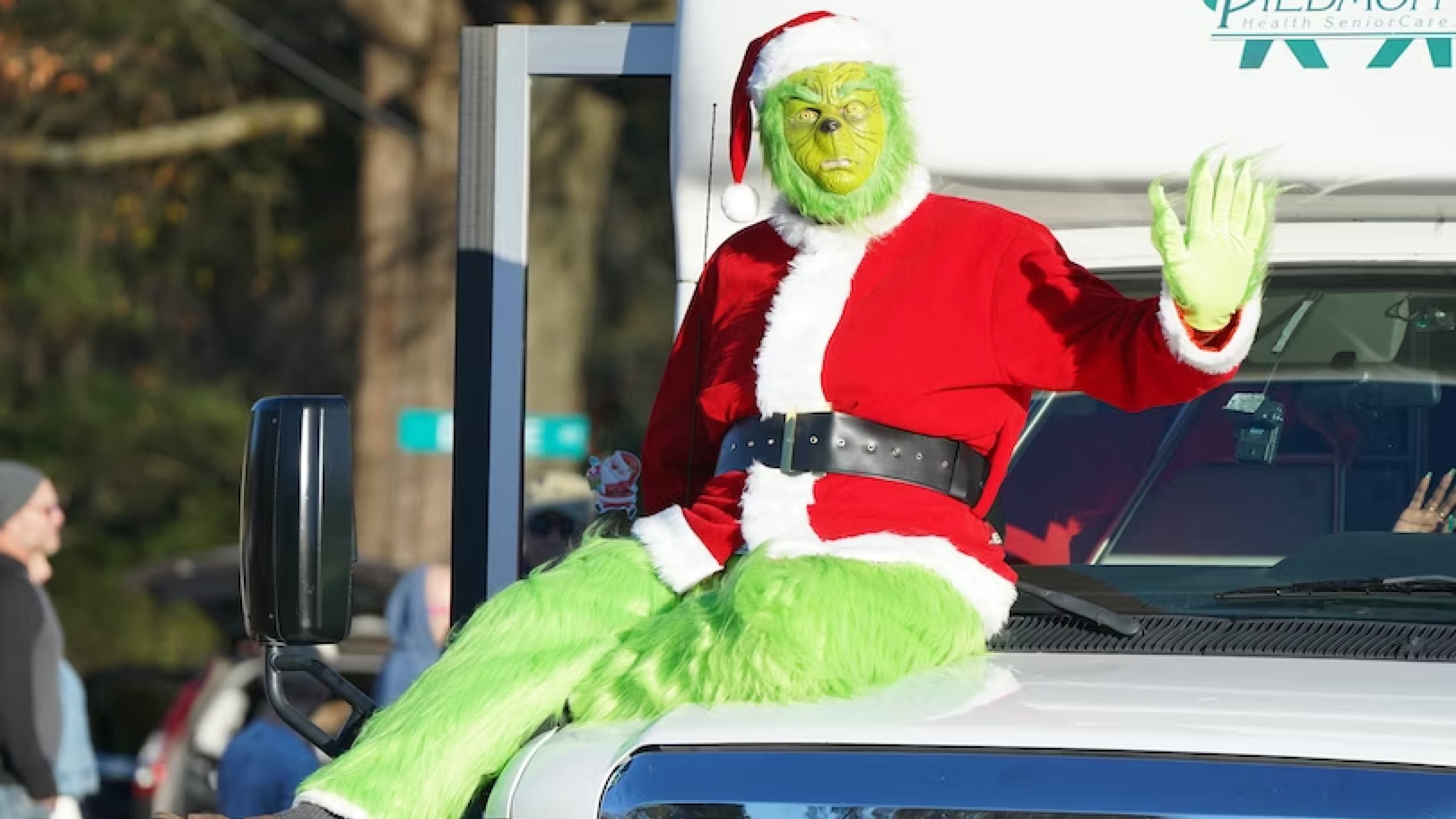 Man dressed as Grinch sitting on a truck