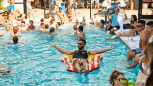 Man floating in pool at party