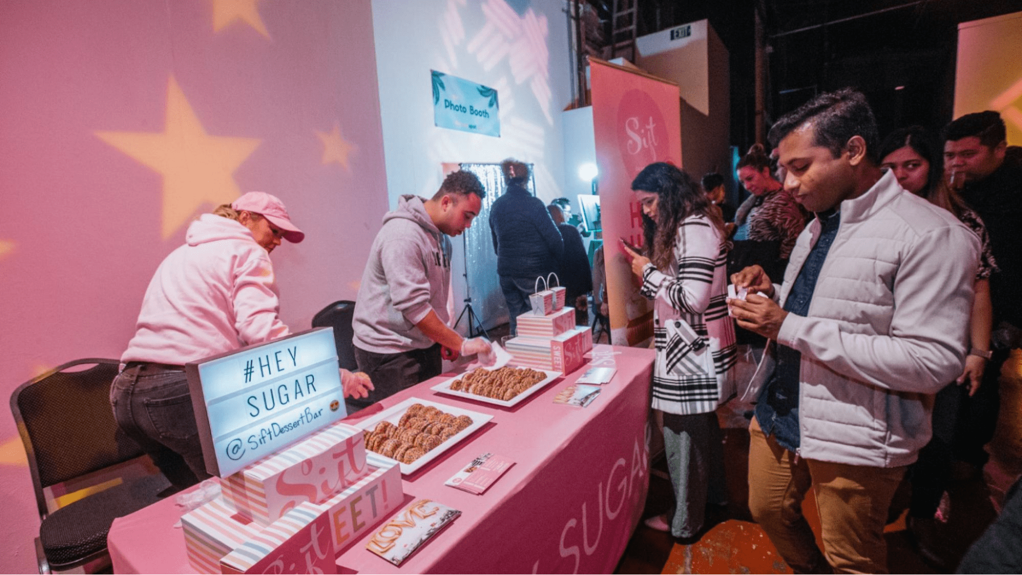 best name for event planning business People at an event booth with the name showing
