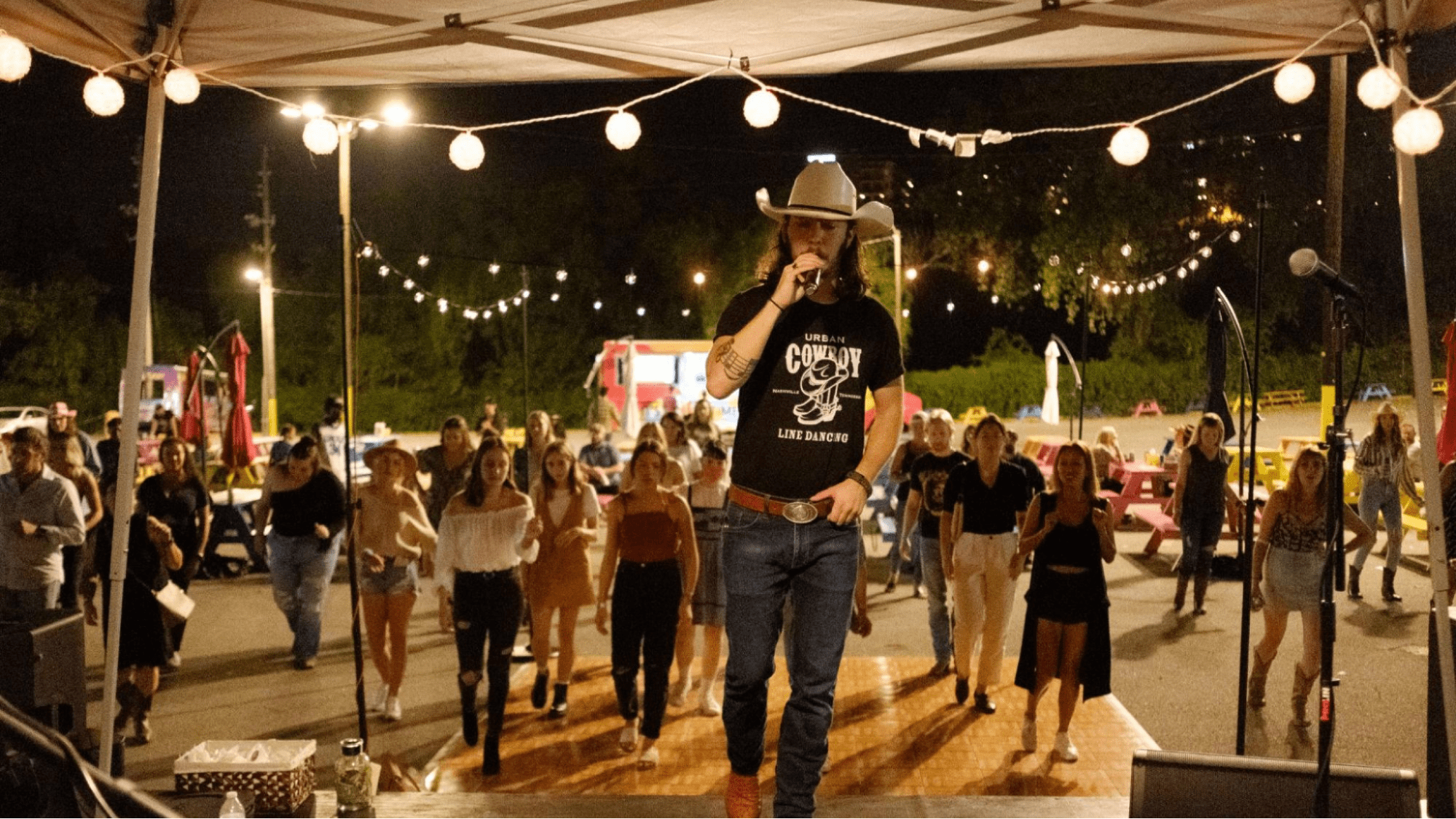 Performer leads country dance on stage