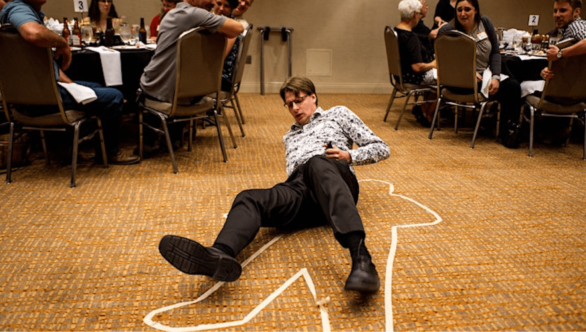 A person pretending to die at a murder mystery event