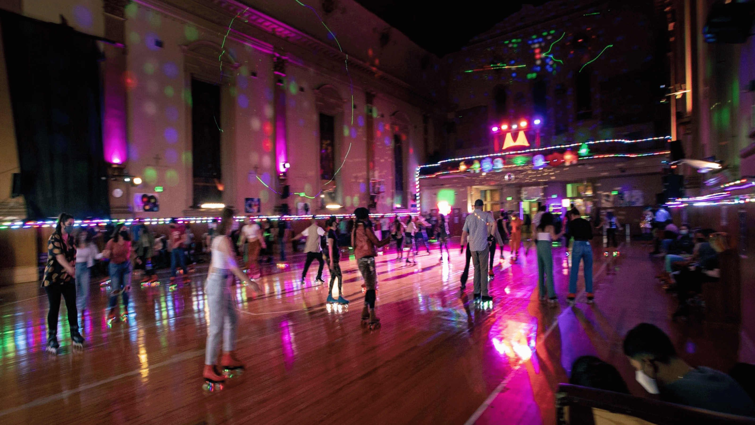 A group of people skating at a roller rink