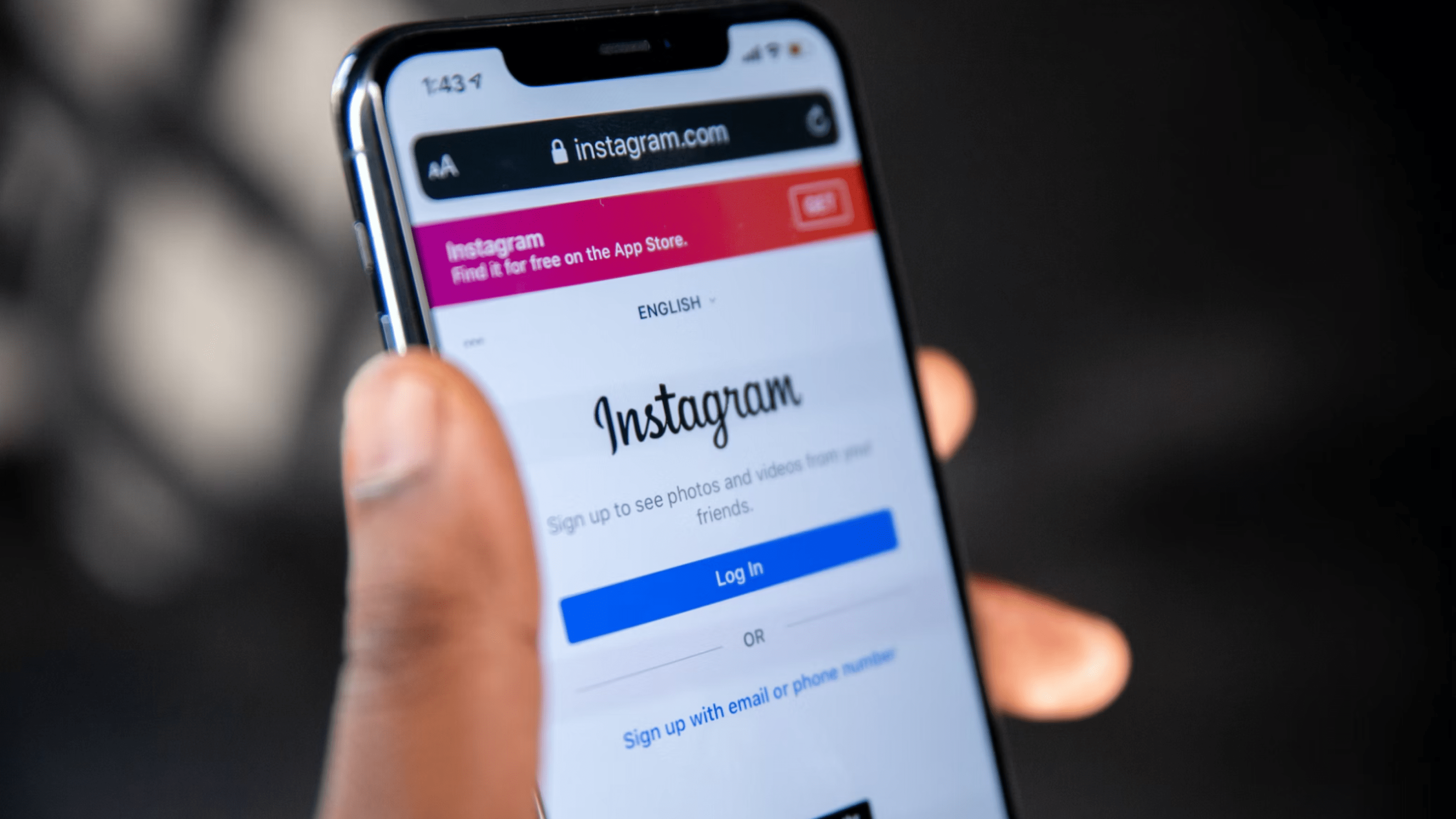Hand holds mobile phone with Instagram log-in on screen