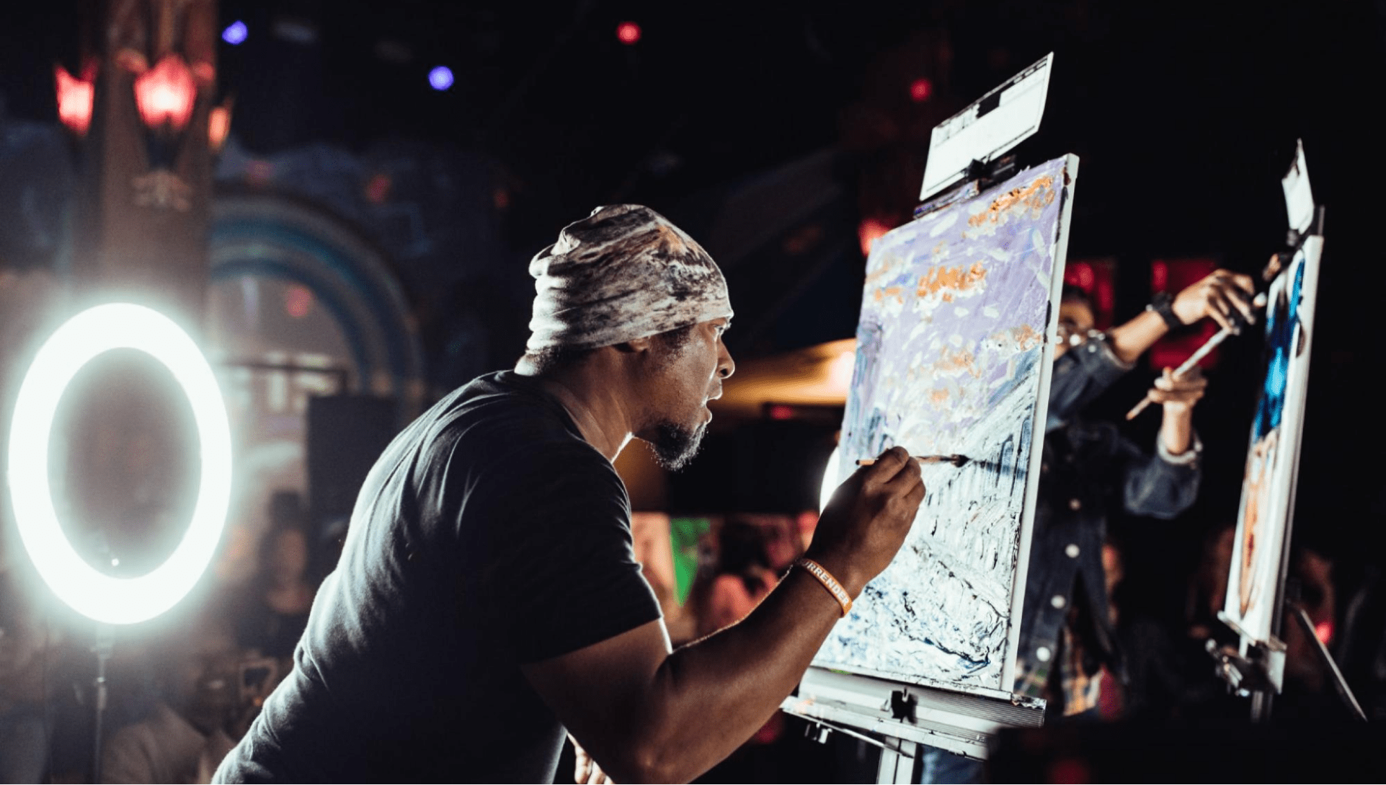 Black artist works on painting on stage