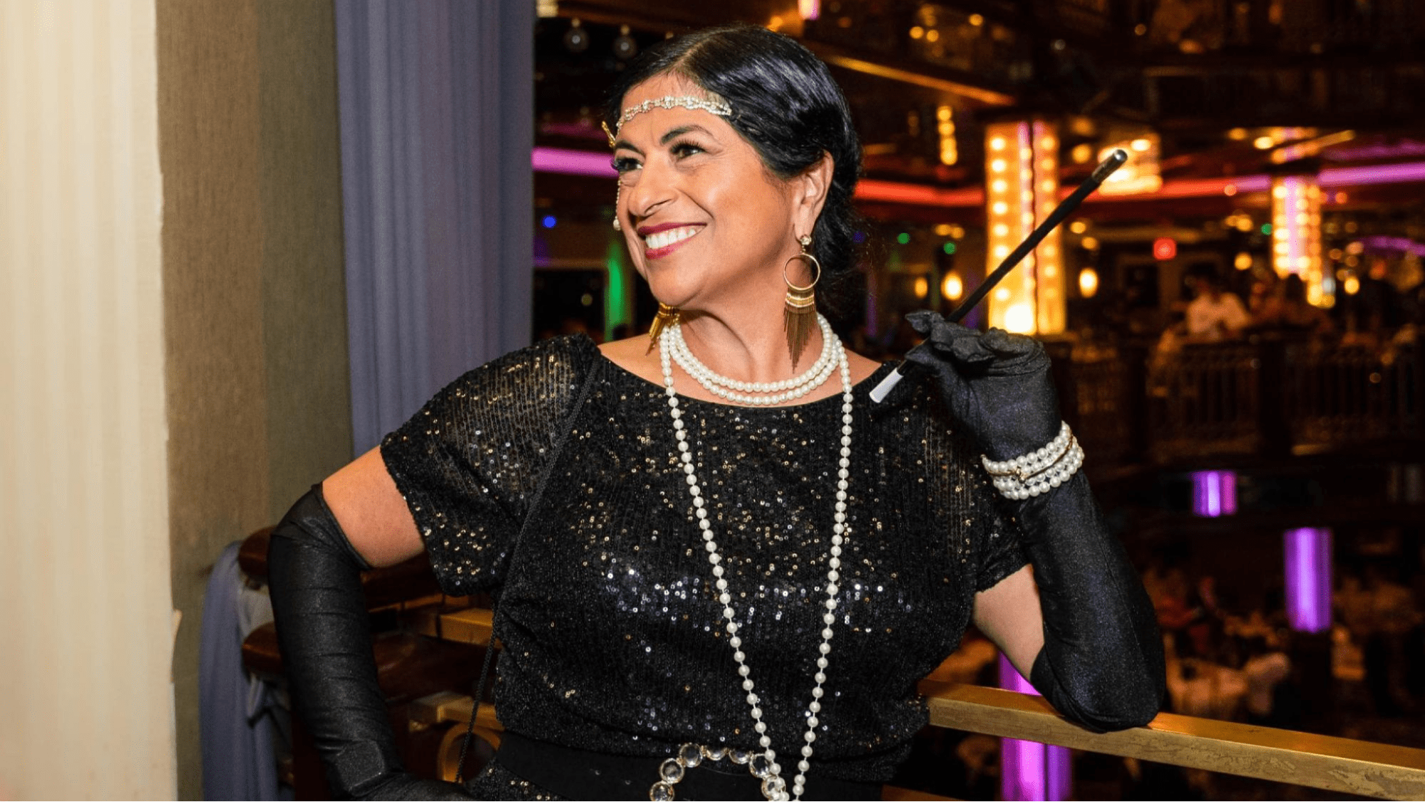 Woman dressed in flapper outfit smiles at party