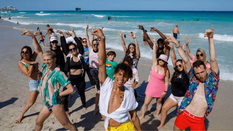 Flash mob dancers perform on a beach