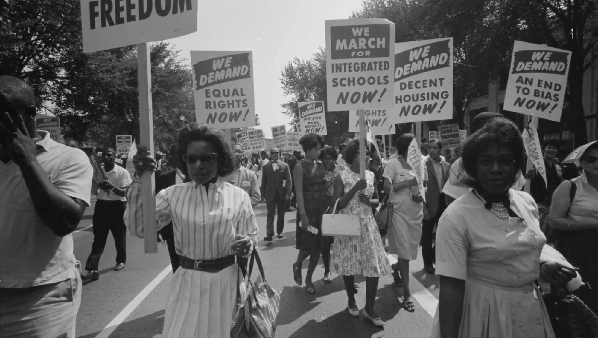 Photo of black people marching down the street holding signs