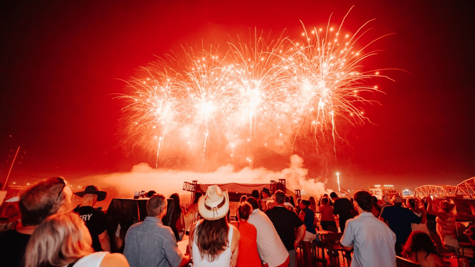 people watching red fireworks