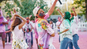 Event creator dances while holding microphone in the middle of a crowd