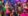 a group of diverse people at a Kitschmas event with gaudy christmas decorations, neon lights, kitschy clothes, and an over the top decorated christmas tree