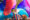 A woman holding colorful fans at a Daybreaker event.